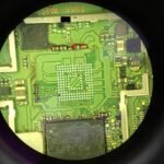 A close up of a circuit board through a magnifying glass.